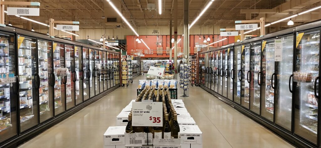Rows of glass-door freezer aisles inside a supermarket.