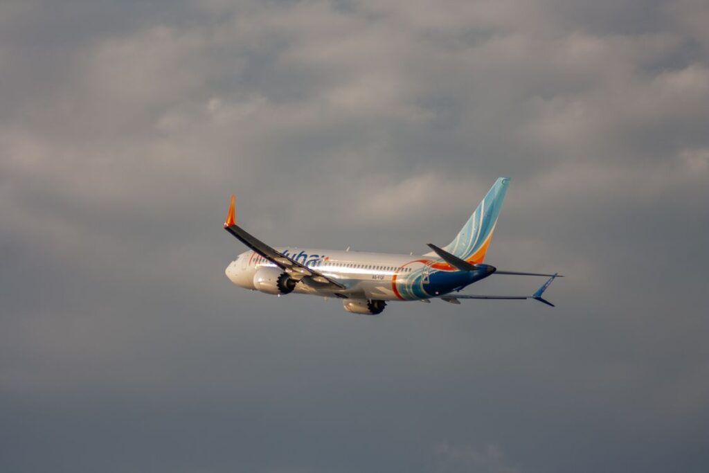 A flydubai passenger jet in flight against dramatic clouds