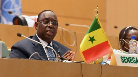 Former Senegalese president Macky Sall speaking into a microphone at a conference table