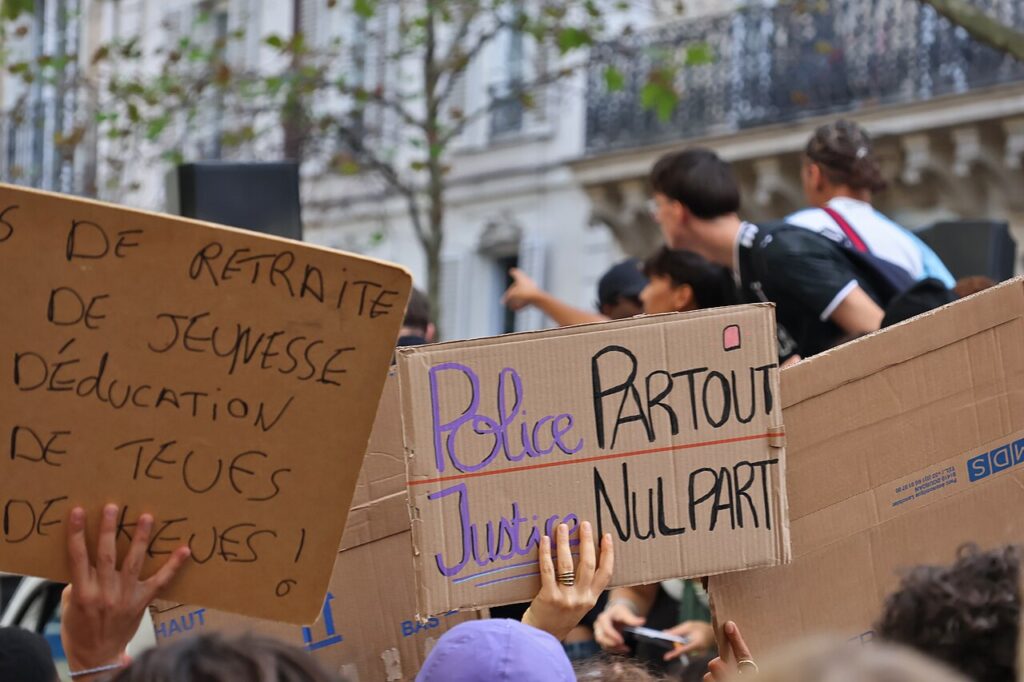 Students holding protest signs during a Paris demonstration in October 2026