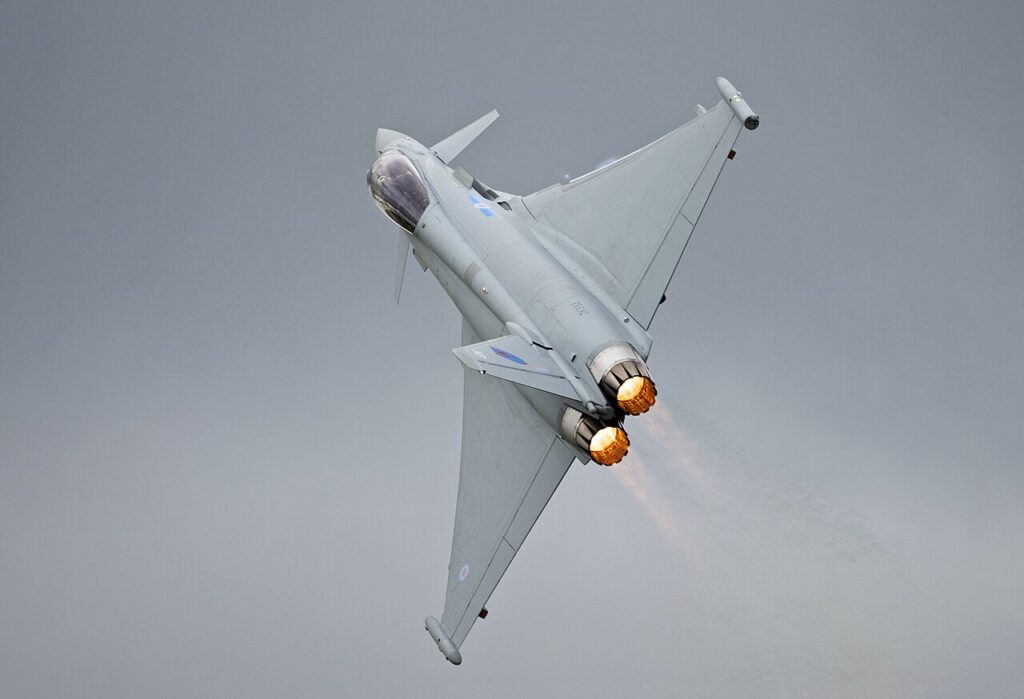 An RAF Eurofighter Typhoon fighter jet in flight with afterburners engaged