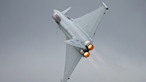 An RAF Eurofighter Typhoon fighter jet in flight with afterburners engaged