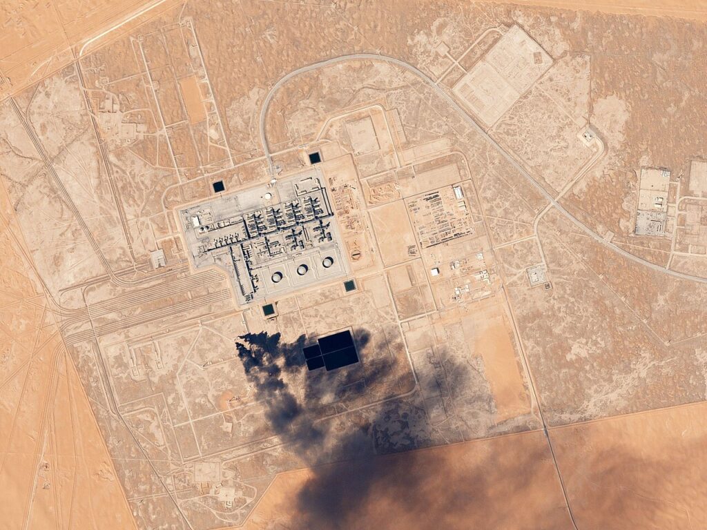 Satellite view of the Khurais oil processing facility in the Saudi desert, showing storage tanks and processing units.