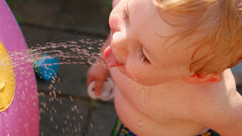 A child cooling off with water on a hot day