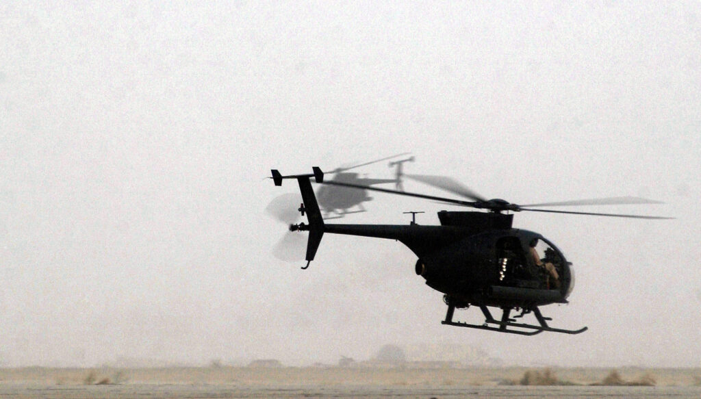 Two US Army AH-6J Little Bird reconnaissance helicopters in flight over Iraq in 2003 — the same aircraft family as the Saudi AH-6i that crashed in Najran