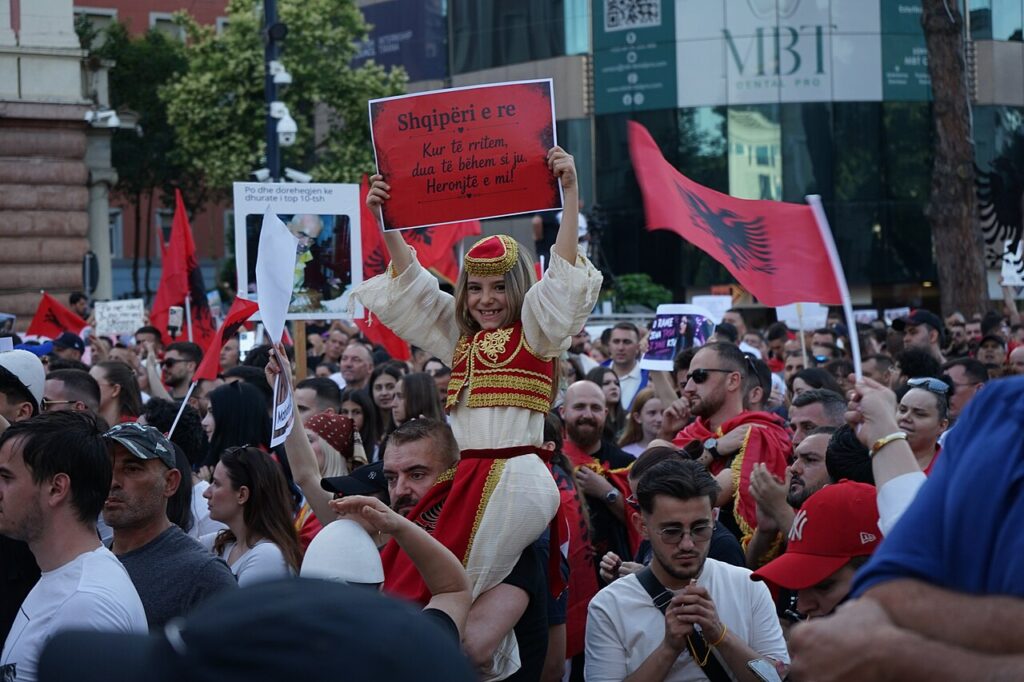 Crowd of protesters waving Albanian flags in central Tirana