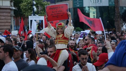 Crowd of protesters waving Albanian flags in central Tirana