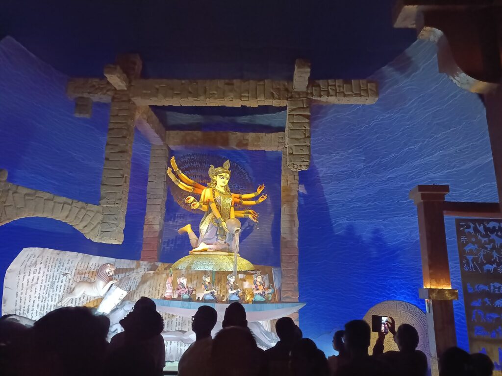 Devotees silhouetted before the Durga idol at the Chorbagan Sarbojanin pandal in Kolkata, photographed in 2025.