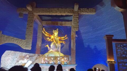 Devotees silhouetted before the Durga idol at the Chorbagan Sarbojanin pandal in Kolkata, photographed in 2025.