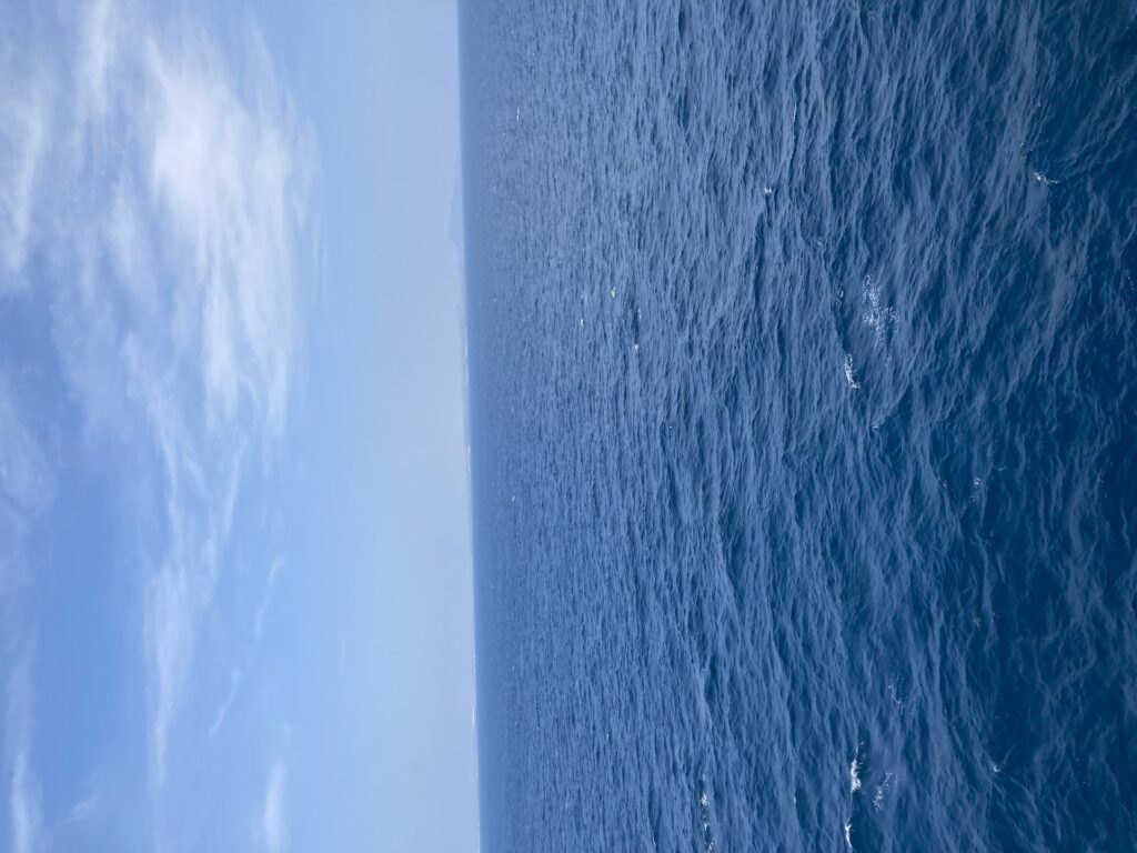 The Bab el-Mandeb Strait seen from mid-channel, looking toward Yemen — the waterway the overcrowded migrant boat was trying to cross when it capsized on the night of October 8-9, 2026.