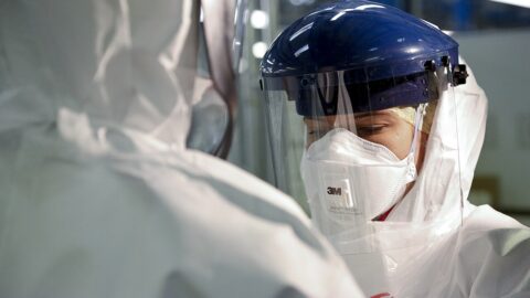 A health worker in full protective equipment, including a face shield and respirator mask, during an Ebola response.