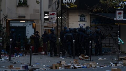 French riot police in protective gear outside a looted shop in Paris during the October 17, 2026 unrest