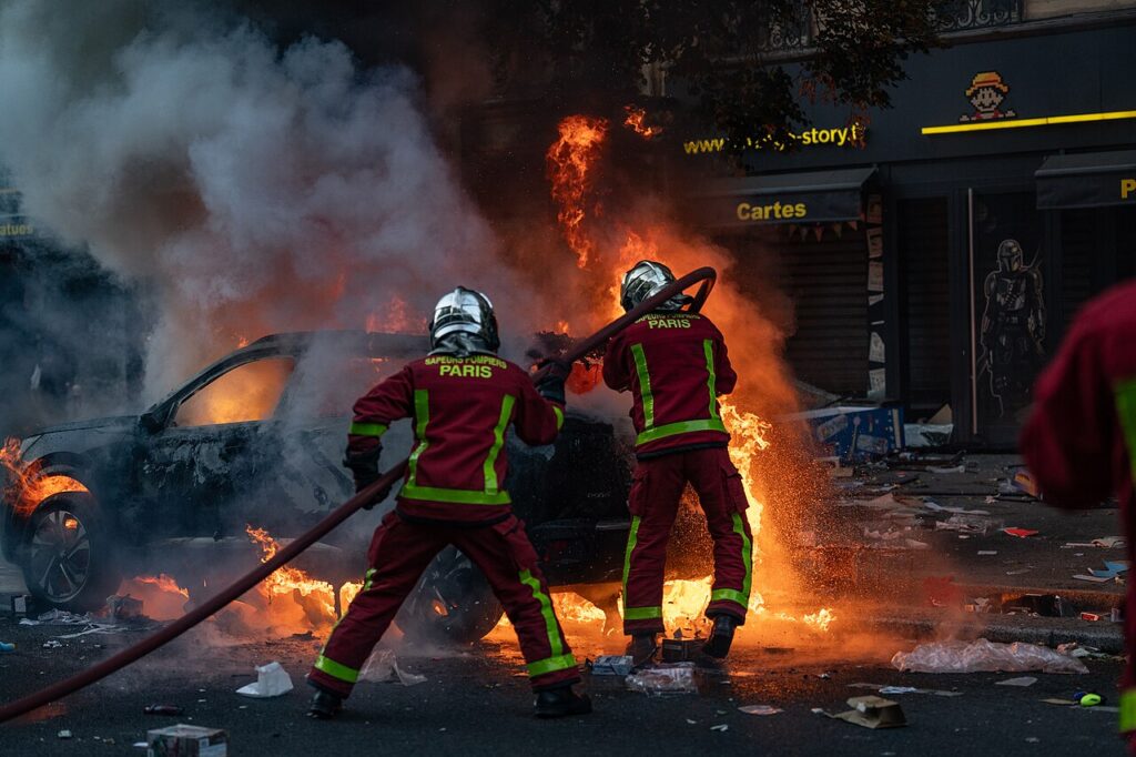 Paris firefighters extinguishing a burning car on a Paris street during the October 17, 2026 riots