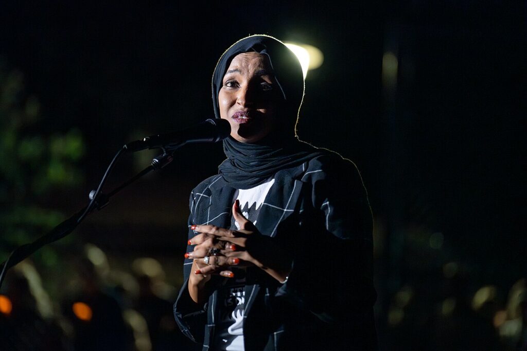 U.S. Representative Ilhan Omar speaks at a microphone during a community vigil in Minneapolis, August 2025