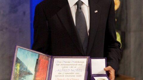 Barack Obama holds his Nobel Peace Prize medal and diploma at the 2009 award ceremony in Oslo City Hall