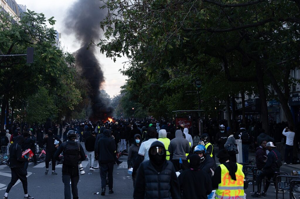 Black smoke rises over a Paris boulevard as protesters gather during unrest in the French capital.