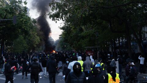 Black smoke rises over a Paris boulevard as protesters gather during unrest in the French capital.
