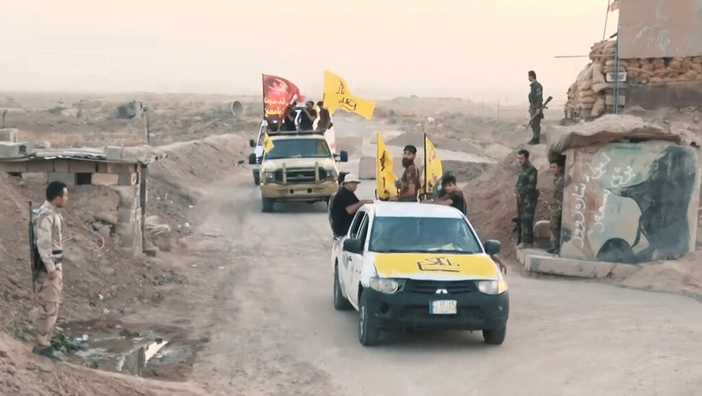 PMF Hashd al-Shaabi fighters with flags at a checkpoint in Iraq