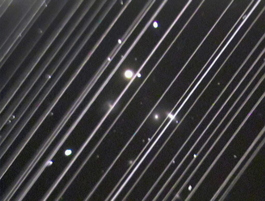 Starlink satellites leaving bright trails across the night sky