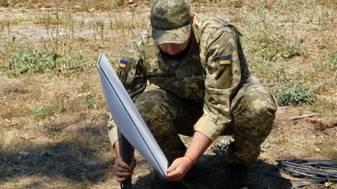 A Ukrainian soldier installs a Starlink satellite terminal in the field