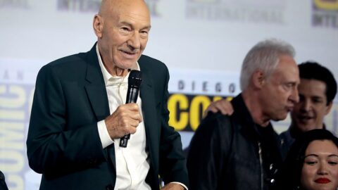 Patrick Stewart smiling with a microphone at a Star Trek panel, with Brent Spiner beside him.