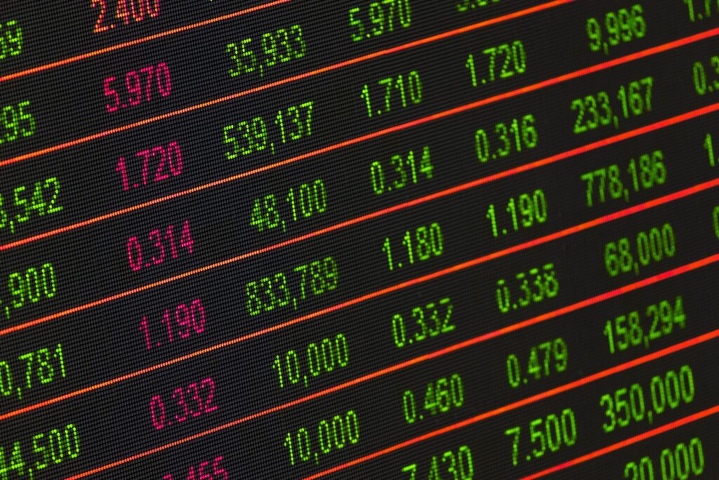 A digital stock exchange board showing flashing share prices in red and green