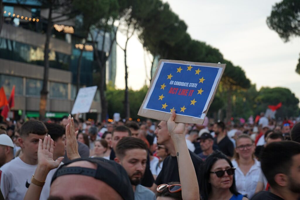 Protesters in Tirana holding a pro-EU sign during a Flamingo movement demonstration