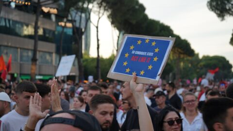 Protesters in Tirana holding a pro-EU sign during a Flamingo movement demonstration