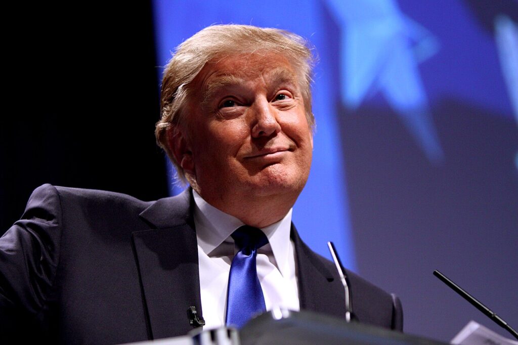 Donald Trump speaking at a podium.