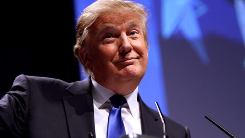 Donald Trump speaking at a podium.