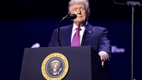 Donald Trump speaking at a rally podium with the US presidential seal