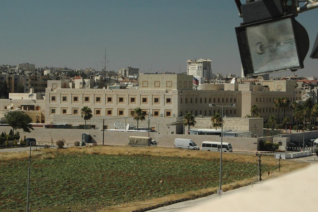 The walled compound of the U.S. Embassy in Amman, Jordan, with the American flag flying above the main building.
